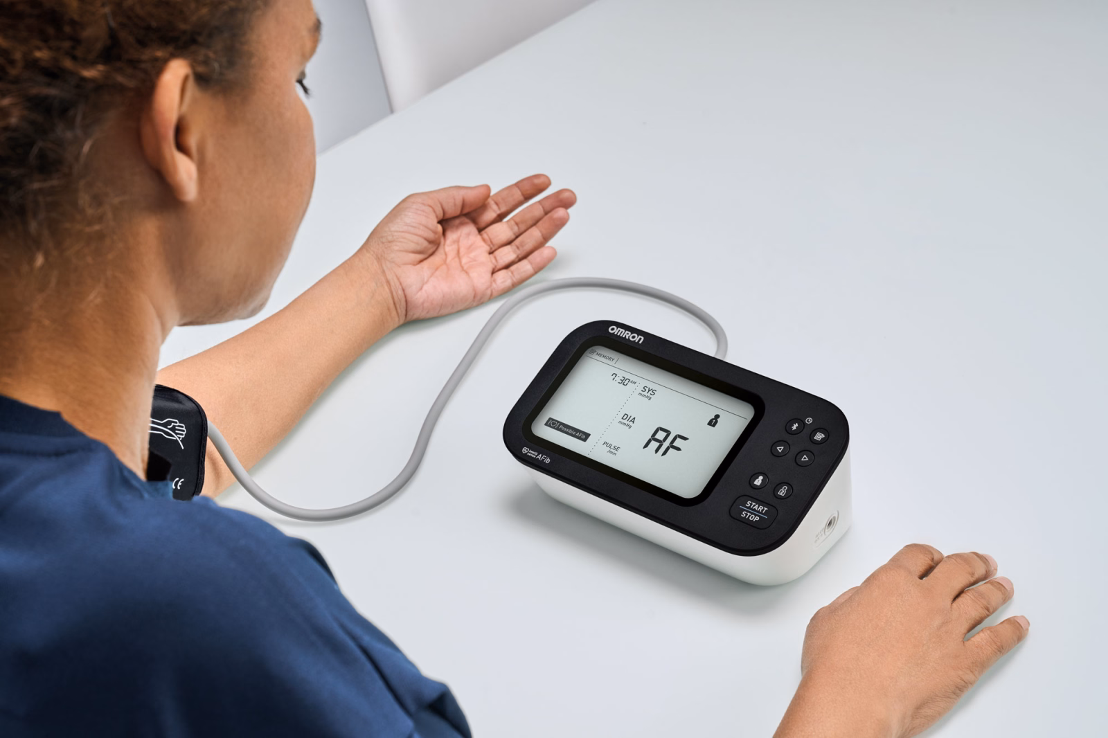 Mujer midiendo su presión arterial con monitor OMRON